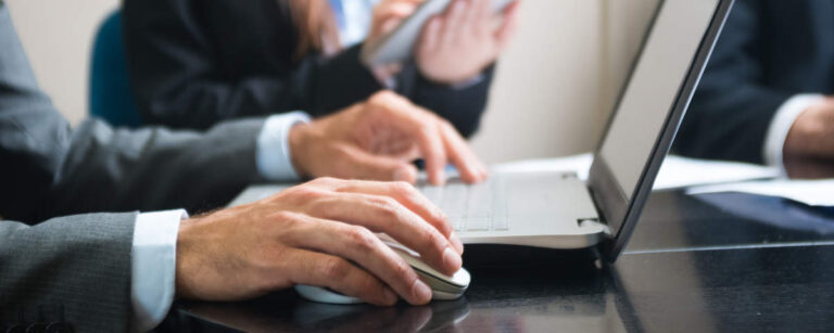 Detail of a person using his laptop computer during a meeting